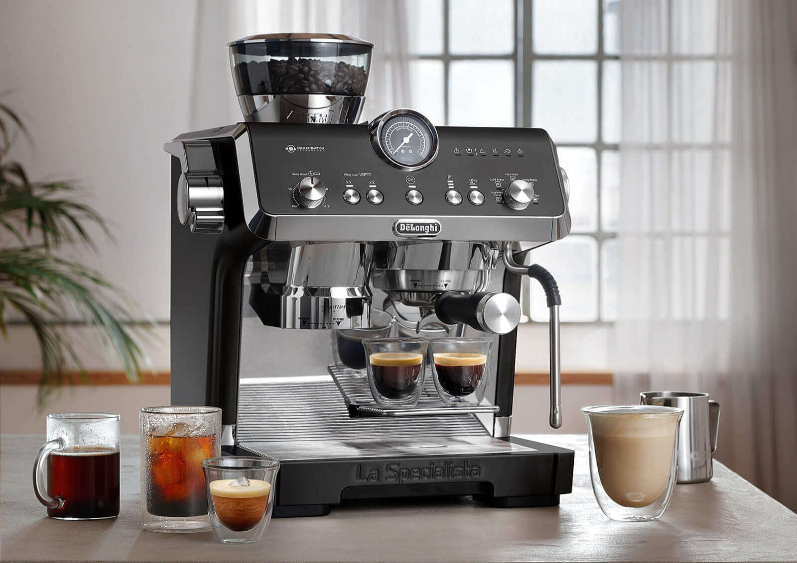 Espresso machine on a kitchen counter with coffee drinks and a cozy living room in the background.